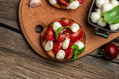 Kiraz domatesli sandviç, mini mozzarella, taze fesleğen yaprağı, ekmek üstü caprese, geleneksel İtalyan aperatifi veya aperatifi, antipasto. afiş, menü, metin için tarif yeri, üst görünüm.
