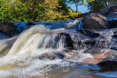 Nehirdeki kayaların üzerinden akan su.