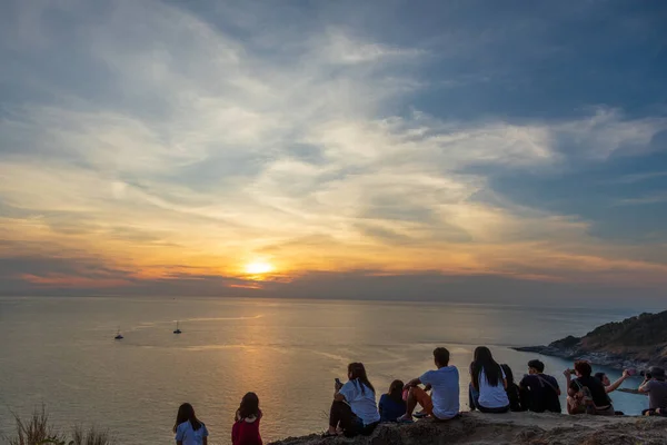 Tambon Rawai, Chang Wat Phuket, 6 Mart 2018 - Bir tepenin üstünde oturan bir grup insan gün batımını izliyor.
