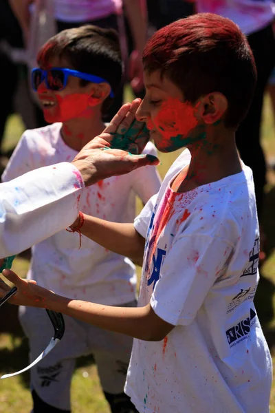 19 Mart 2022 - Genç çocuğun yüzü annesi tarafından Cumming, GA 'daki Holi Festivali' nde resmedildi