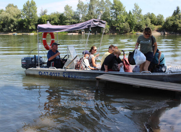 Россия, Новосибирск 01.08.2021: лодка с пассажирами перевозит людей вдоль реки на пароме для прогулок туристов
