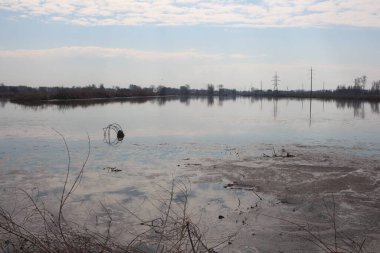 Ufuk çizgisi olan kirli göl doğayla iç içe geçmiş çöplük.