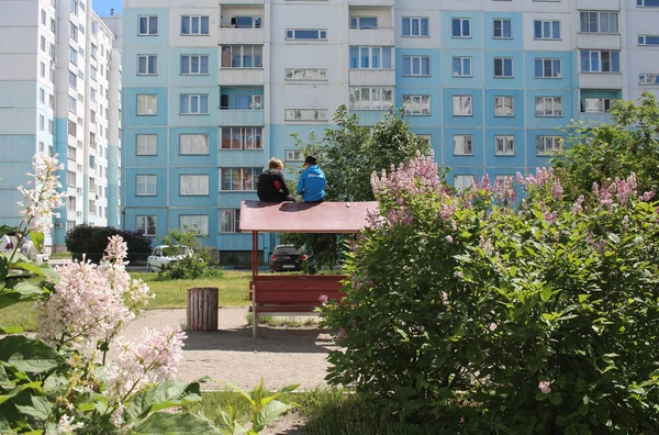 Rusya, Novosibirsk 09.06.2021: Çocuklar yazın bahçedeki terasın çatısında oturmuş bahçede oynuyorlar.