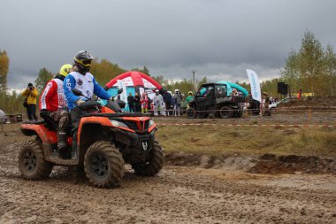 Rusya, Novosibirsk 25.09.2021: ATV 'ler ve arazi araçları üzerinde turistler yarışa kirli bir yoldan gidiyor