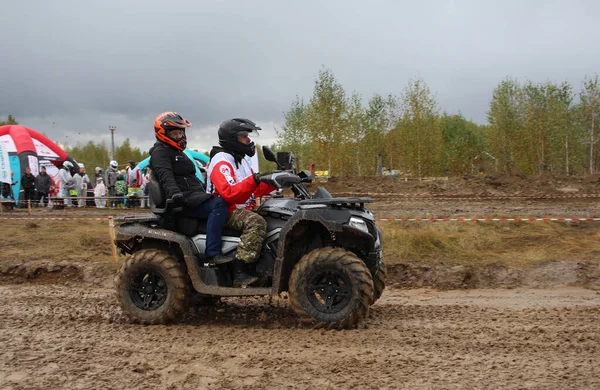 Rusya, Novosibirsk 25.09.2021: ATV 'ler ve arazi araçları üzerinde turistler yarışa kirli bir yoldan gidiyor