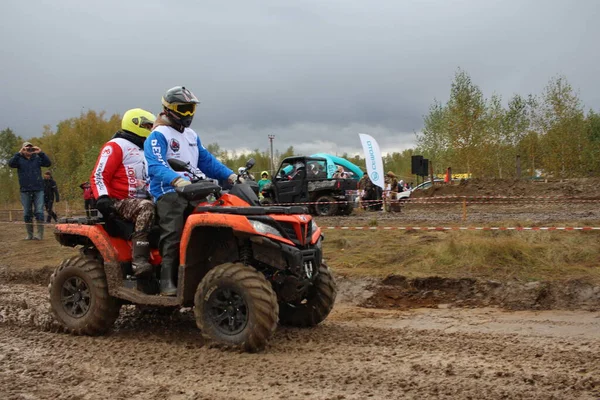 Rusya, Novosibirsk 25.09.2021: ATV 'ler ve arazi araçları üzerinde turistler yarışa kirli bir yoldan gidiyor