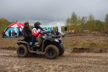 Rusya, Novosibirsk 25.09.2021: ATV 'ler ve arazi araçları üzerinde turistler yarışa kirli bir yoldan gidiyor