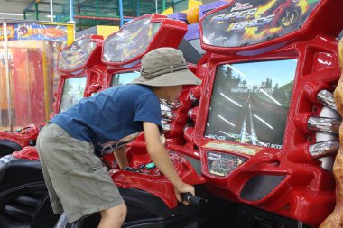 Russia, Novosibirsk 20.07.2021: a boy plays on an attraction in a racing motorcycle simulator