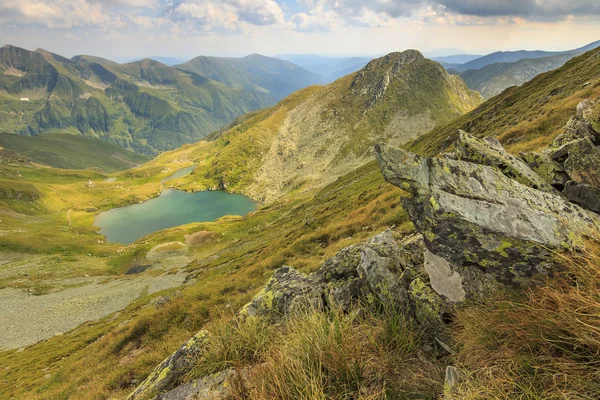 Cumes de montanha e lago alpino, lago Capra, montanhas Fagaras, Cárpatos, Roménia — Fotografia de Stock