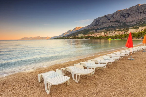 Liegestühle und Sonnenschirme am Strand, makarska, kroatien, europa — Stockfoto