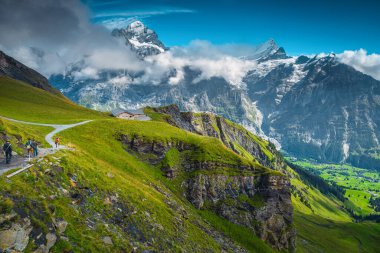 Dağdaki yürüyüşçüler manzaranın tadını çıkarıyorlar. Yüksek dağları ve buzulları olan güzel doğa yerleri, Grindelwald, Bernese Oberland, İsviçre, Avrupa