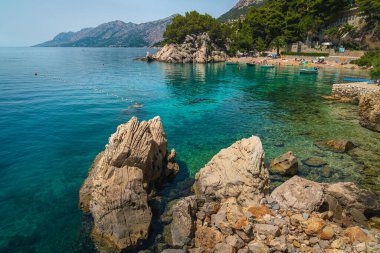 Amazing beach and rocky seashore with anchored boats, Brela, Dalmatia, Croatia, Europe