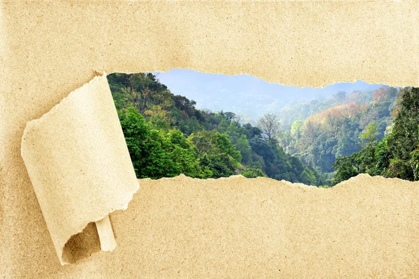 Uitzicht op de bergen achter gescheurd gerecycleerd papier — Stockfoto