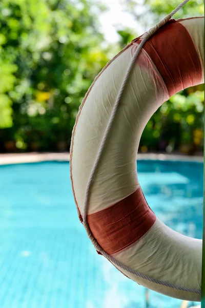 Lifebuoy pendurado em um feixe de madeira na piscina — Fotografia de Stock