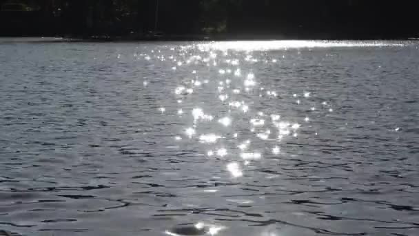 在湖面上反射明亮阳光的波浪形闪光水的选择性聚焦 带有非常柔和的波纹 — 图库视频影像