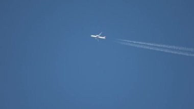 Jet uçakları gökyüzünde yükseklerde uçuyor açık mavi gökyüzünde kontrastlar bırakıyor.