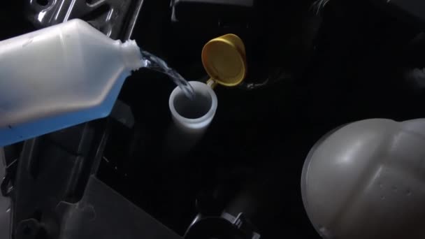 在发动机上的汽车的挡风玻璃刮水器系统中填充防冻剂 — 图库视频影像
