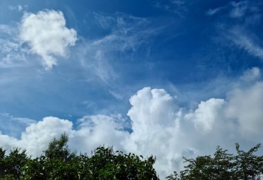 Güzel pofuduk beyaz bulut oluşumları Derin mavi bir yaz gökyüzünde