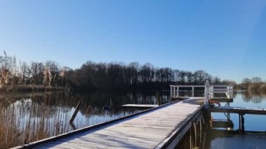 Göl kenarında mavi gökyüzü olan bir iskelede yürürken güzel manzara.