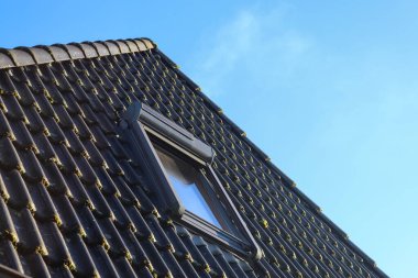 Siyah çatı kiremitleri ile Velux tarzı çatı penceresini aç