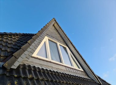 Siyah çatı kiremitleri ile Velux tarzı çatı penceresi