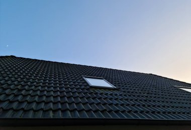Siyah çatı kiremitleri ile Velux tarzı çatı penceresi