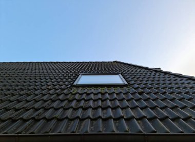 Siyah çatı kiremitleri ile Velux tarzı çatı penceresi