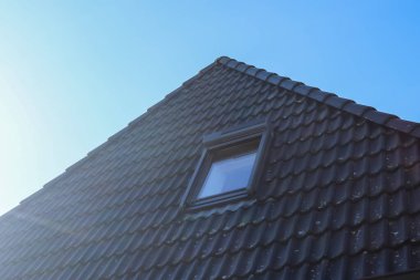 Siyah çatı kiremitleri ile Velux tarzı çatı penceresini aç