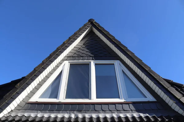 Siyah çatı kiremitleri ile Velux tarzı çatı penceresini aç