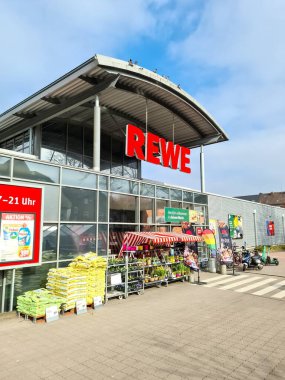 Güneşli havada Almanya 'da bir REWE süpermarketinin girişi
