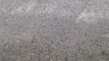 Dolu fırtınası asfalt bir yola düşüyor. Dolu taşları yerden yükseliyor..
