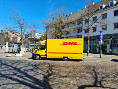 Neumuenster, Almanya - 16. Nisan 2022: Alman paket servisi DHL 'nin sarı minibüsü şehrin güneyine park etti