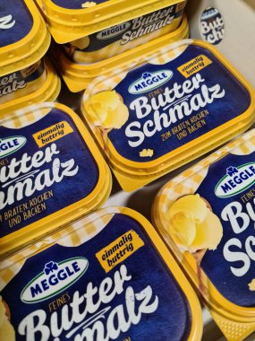 Kiel, Almanya - 16. Nisan 2022: Bir süpermarkette Meggle marka tereyağı dolu bir yığın sarı paket