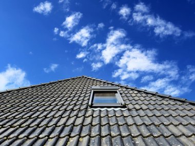 Siyah çatı kiremitleri ile Velux tarzı çatı penceresini aç