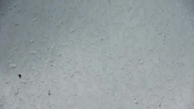 Kirli bir pencereden süzülen yağmur damlaları.