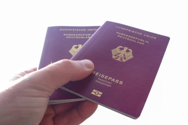 Bir erkek pasaport kontrolü için iki Alman pasaportu tutuyor.