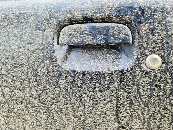 A very dirty car handle at a black car door
