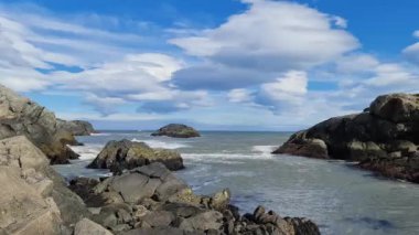 İzlanda 'da siyah kumlu kayalık bir sahilde sörf..