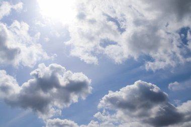 Parlak güneş ışınlarının güzel manzarası, mavi gökyüzünde parlayan mercekler ve bulutlar.