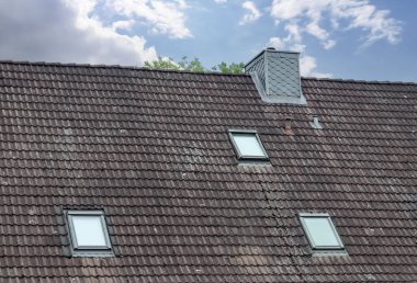 Koyu çatı kiremitleri ile Velux tarzı çatı penceresi
