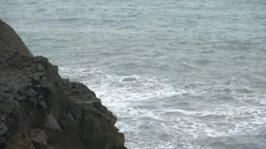 Strong surf at the basalt rocks of dyrholaey on Iceland.