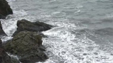 İzlanda 'daki Dyrholaey' in bazalt kayalarında güçlü sörfler..