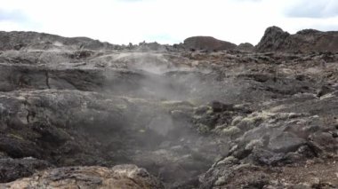 Unreal volcanic landscape in Iceland with steaming rocks on a volcano.