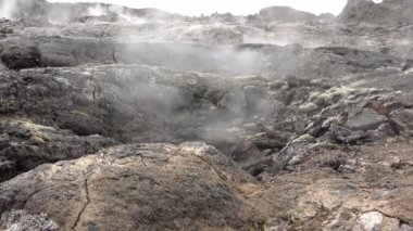 Unreal volcanic landscape in Iceland with steaming rocks on a volcano.