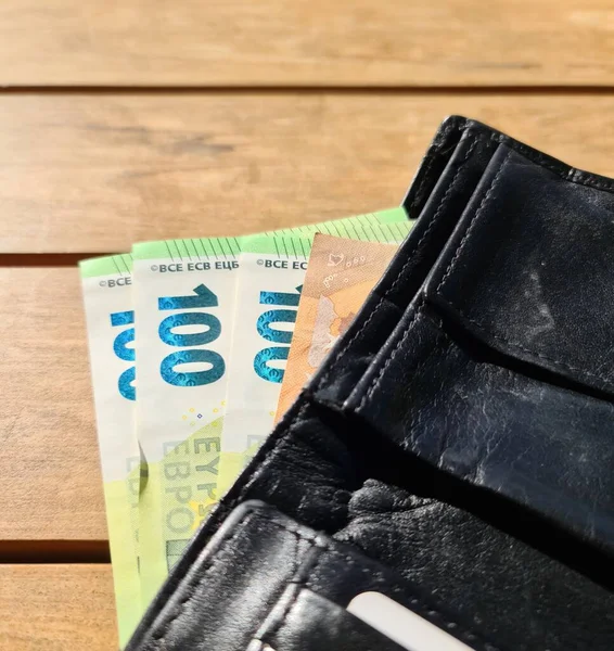 Black Leather Wallet Containing Several 100 Euro Banknotes — стоковое фото