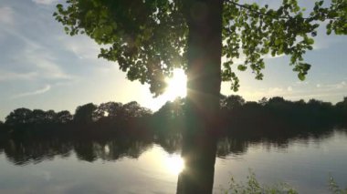 Beautiful view at a lake with the light of the sunset on the water surface.