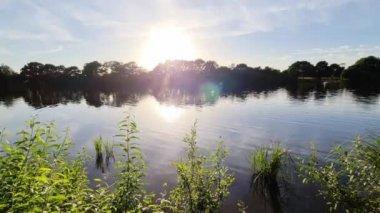 Beautiful view at a lake with the light of the sunset on the water surface.
