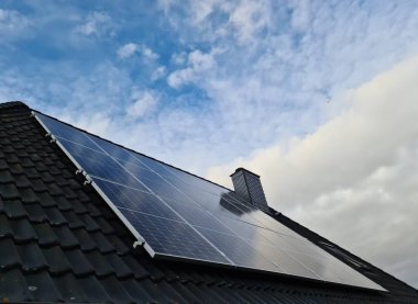 Güneş panelleri bir konutun çatısında temiz enerji üretiyor.