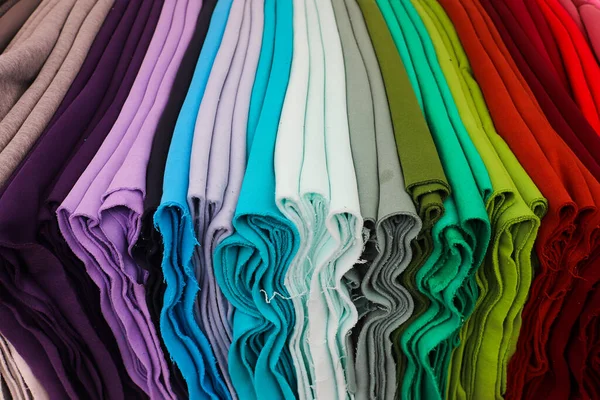 Detailed close up view on samples of cloth and fabrics in different colors found at a fabrics market.