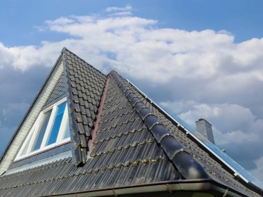 Siyah çatı kiremitleri ile Velux tarzı çatı penceresi